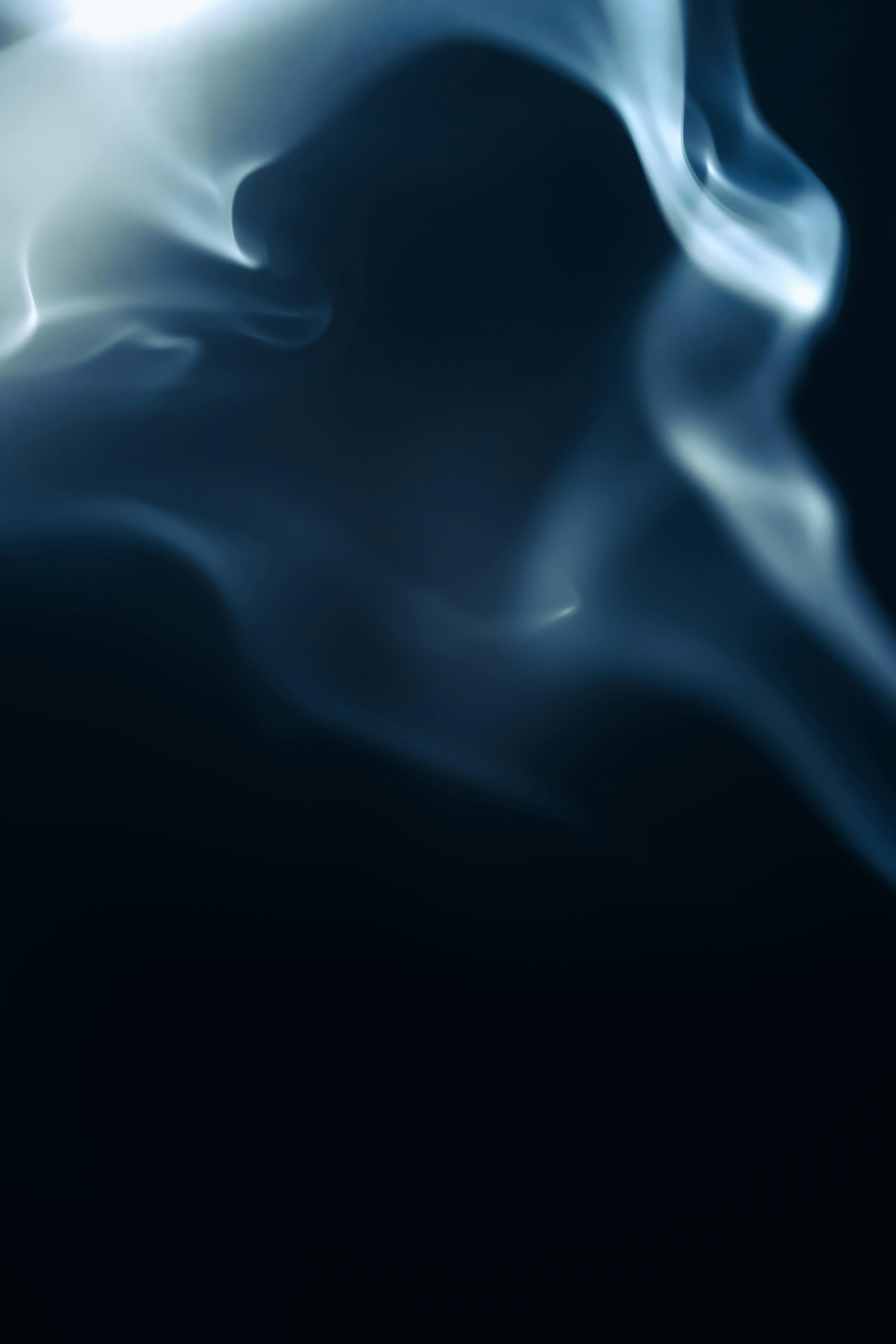 backlit smoke rising against dark background