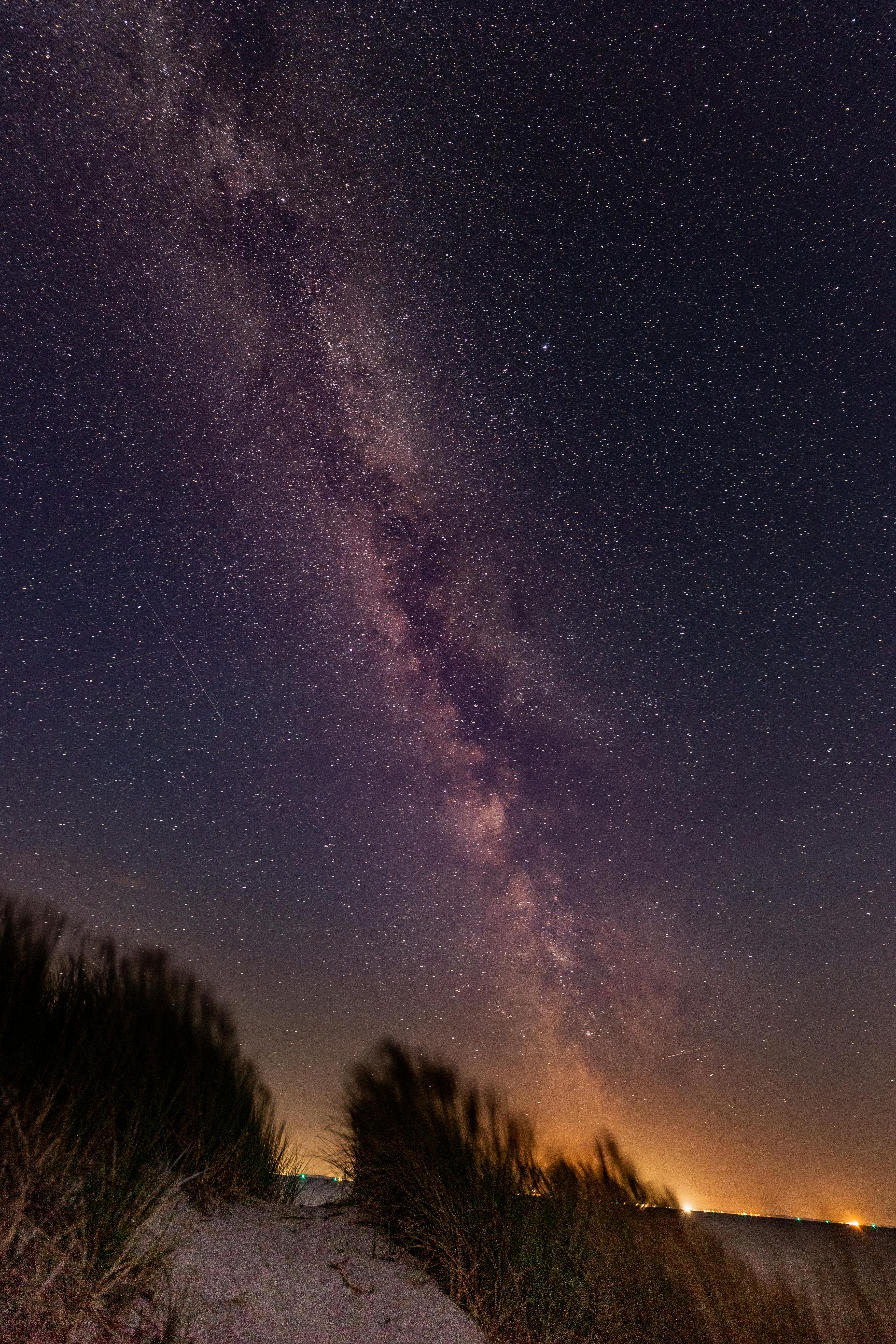 bright milkyway stretching above a beach entrance