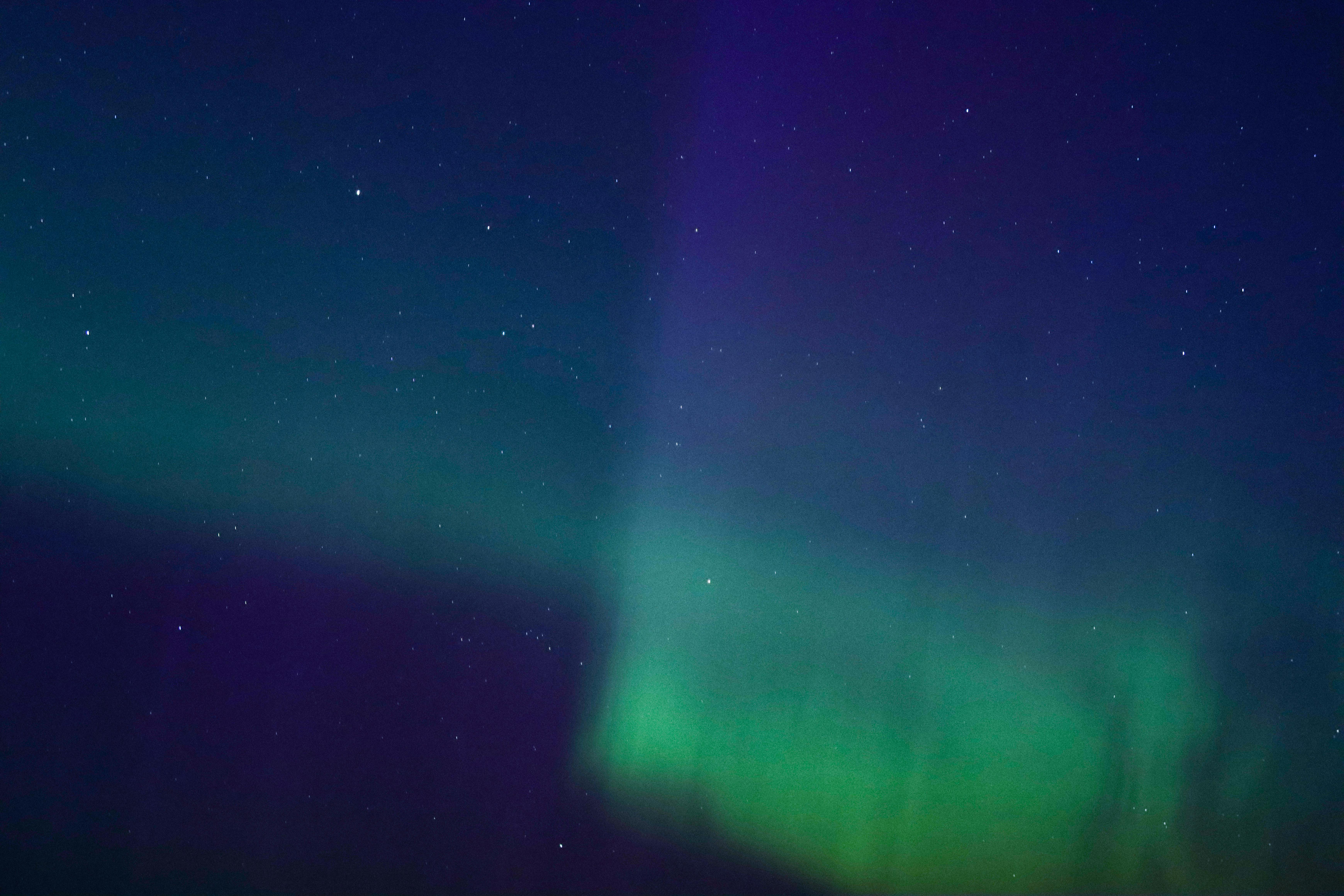 bright green northern lights against dark blue sky