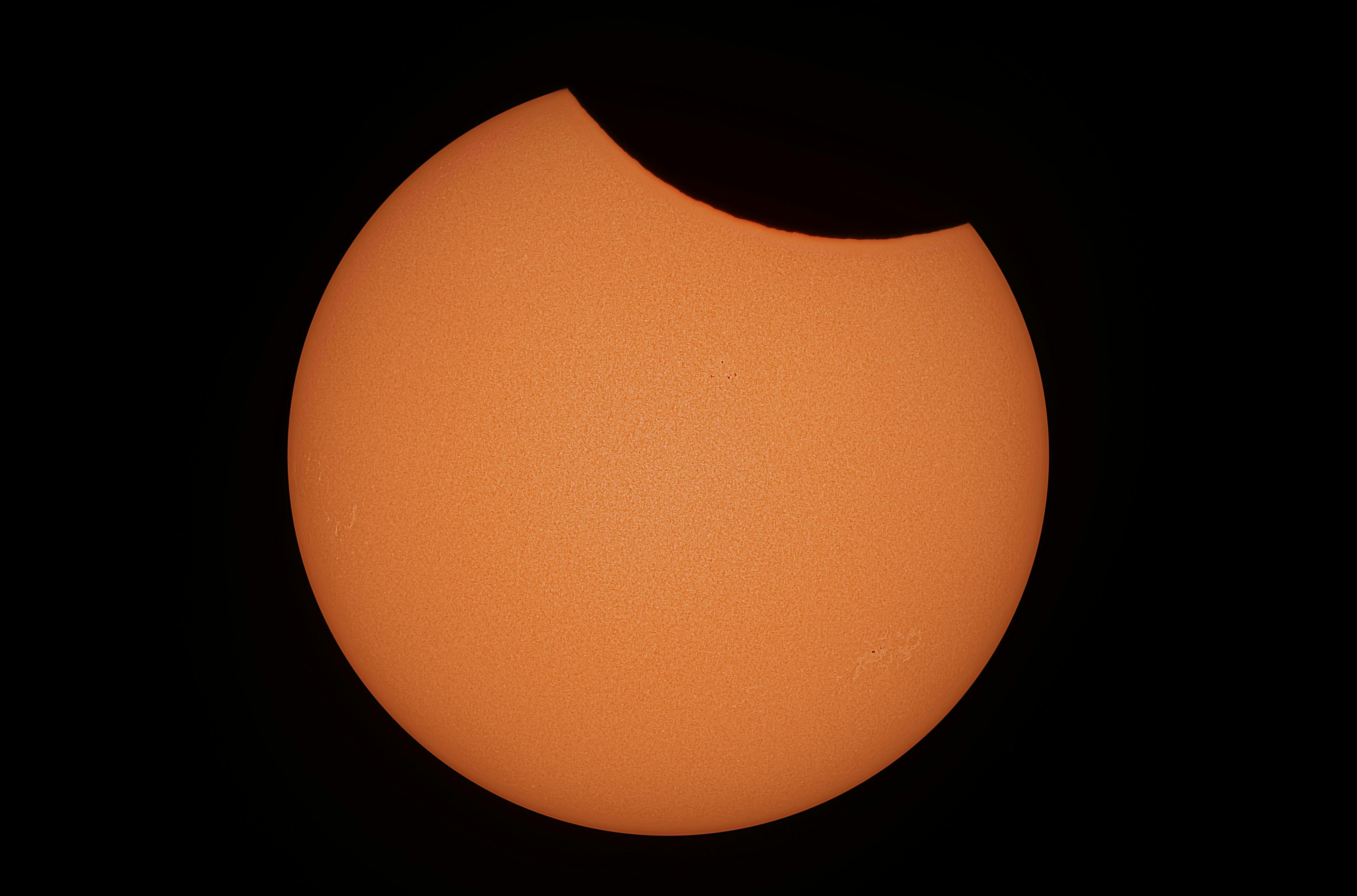 partial solar eclipse photo yellow against black background